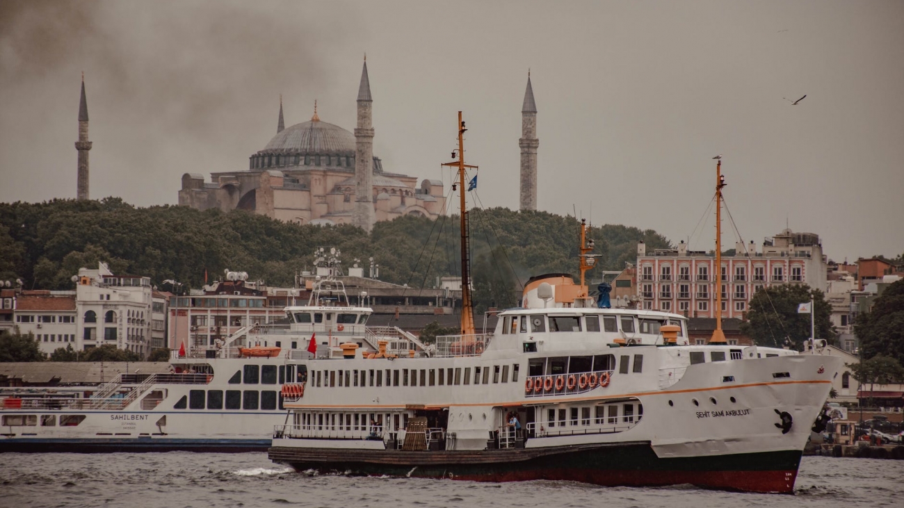 modern ships sailing on canal in old city